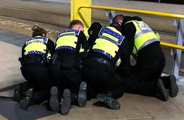 Polizisten halten am Bahnhof Victoria ...schen mit einem Messer verletzt hatte.  | Foto: dpa