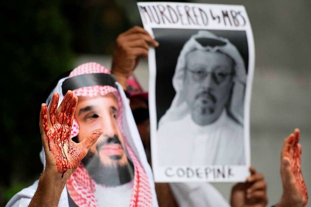 Kunstblut klebt an den Hnden der Demo...rgt die Maske des saudischen Prinzen.  | Foto: AFP