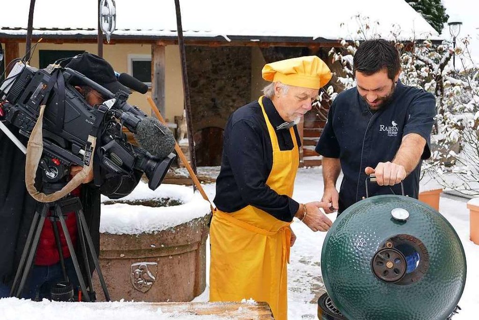 Schnee-Grillen: Steffen Disch zeigt dem französischen Journalisten André Muller (in gelb) die Sellerie auf dem Grill. (Foto: Nikola Vogt) Schnee-Grillen: Steffen Disch zeigt dem französischen Journalisten André Muller (in gelb) die Sellerie auf dem Grill. (Foto: Nikola Vogt)