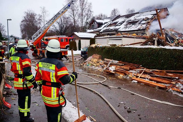 Feuerwehrleute stehen bei einem zerstrten Reihenhaus.  | Foto: dpa