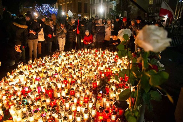 Menschen stellen bei einem Gedenkmarsc...n Danzig, Pawel Adamowicz, Kerzen auf.  | Foto: dpa