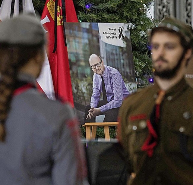 Die Ehrengarde vor einem Bild des getteten Bgermeisters Pawel Adamowicz.   | Foto:  afp