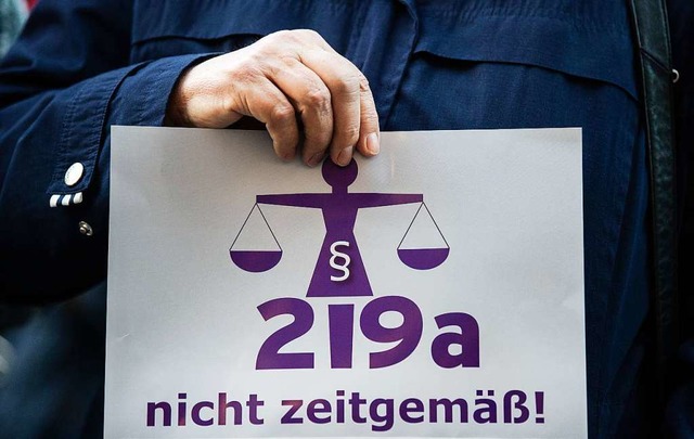 Eine Frau hlt bei einer Kundgebung vo...der Aufschrift 219a nicht zeitgem!  | Foto: dpa