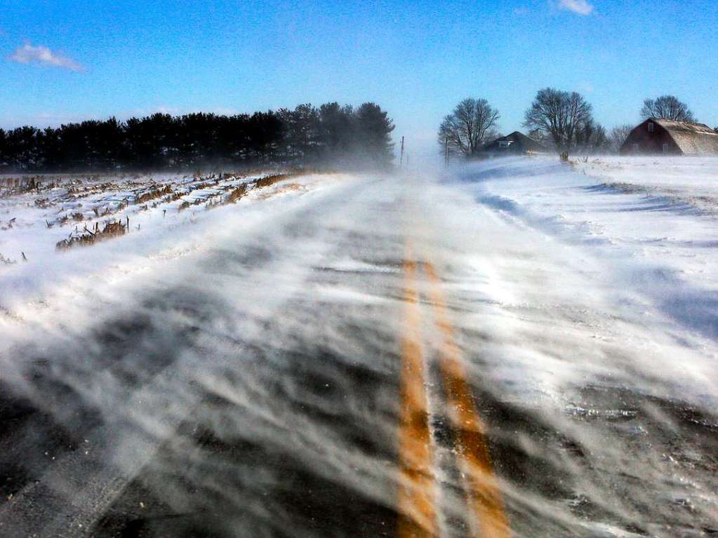 Schnee weht ber eine Strae in der Nhe von Mount Joy in Lancaster County, und verdeckt die Sicht auf dei Fahrbahnen dabei teilweise.