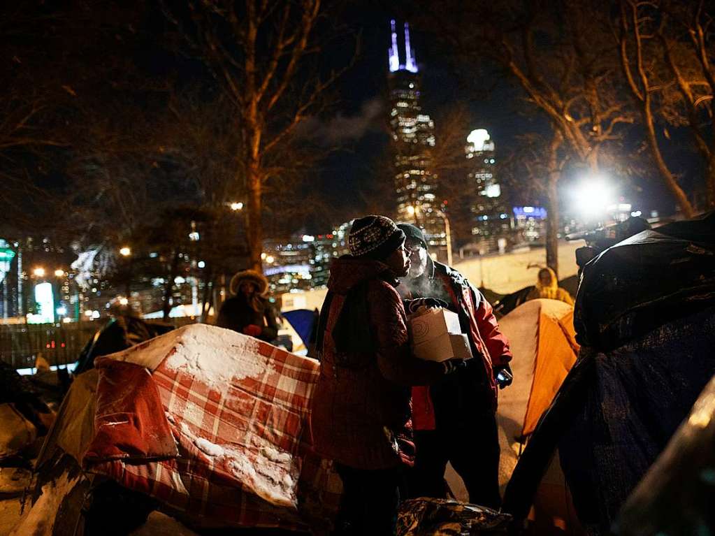 Ein Mitglied der Heilsarmee verteilt in Chicago Essen an eine Frau  die in einem Zelt bernachtete.