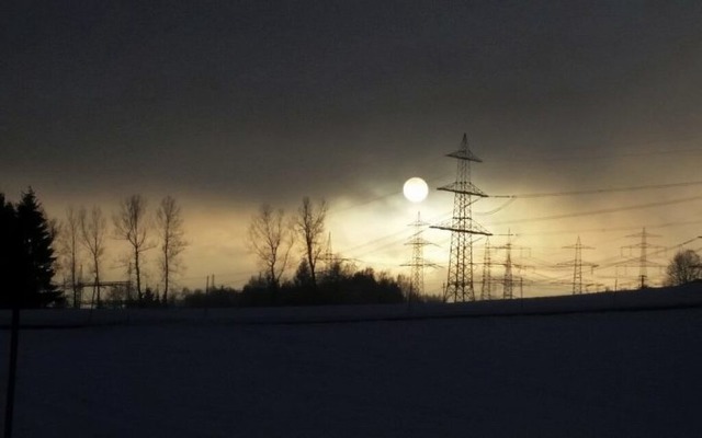 Hinter den Stromleitungen geht die Sonne unter.  | Foto: Elke Schmid