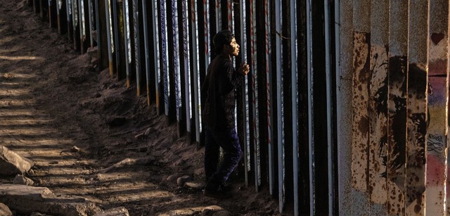 Ein Mann schaut von der mexikanischen ...uana, durch den Grenzzaun in die USA.   | Foto: afp