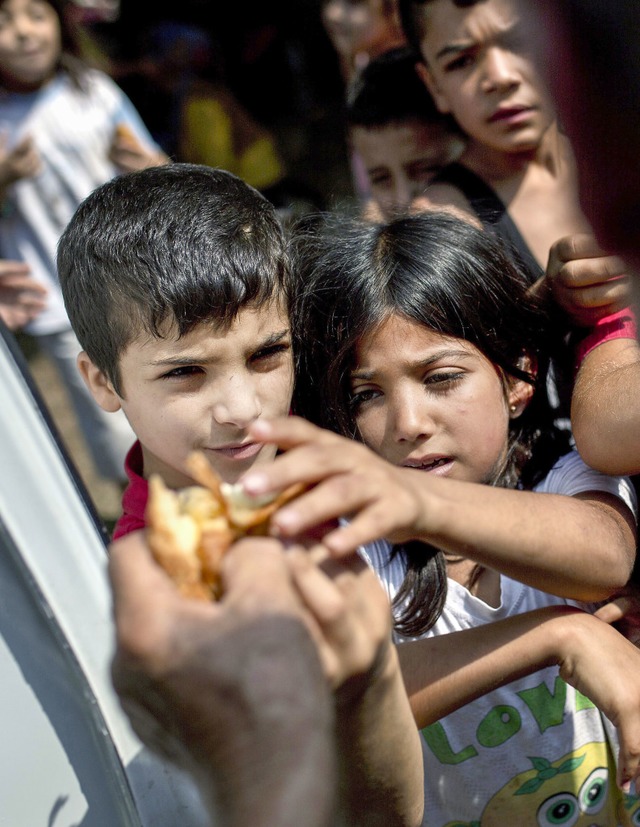 Diese Flchtlingskinder sind auf der I...randet. Offenbar ist ihr  Hunger gro.  | Foto: AFP