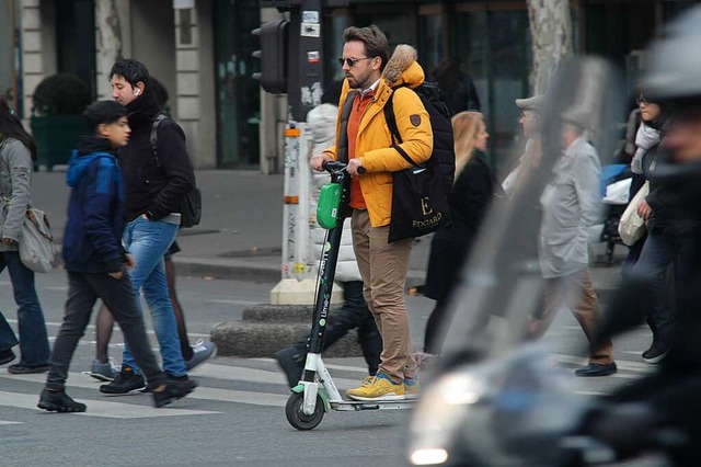 Ein Mann flitzt mit einem E-Tretroller durch Paris.  | Foto: Knut Krohn