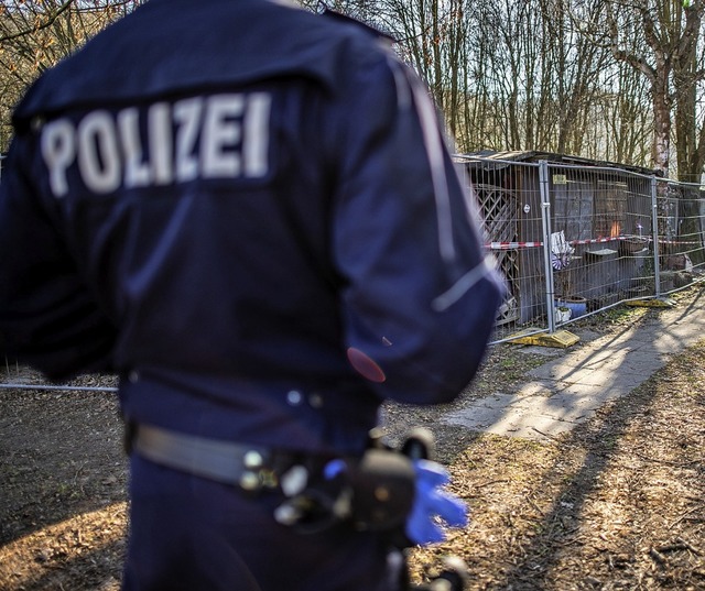 Ermittler vor der abgeriegelten Htte,...ie Taten begangen worden sein sollen.   | Foto: dpa