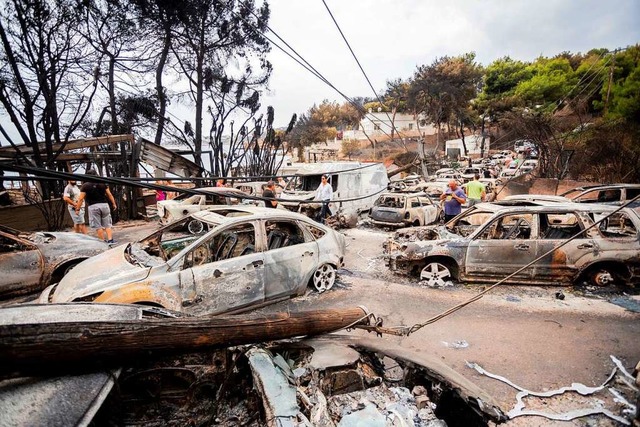 Am Tag nach dem Feuer stehen verbrannte Autos auf der Strae in Mati.  | Foto: Christoph Soeder