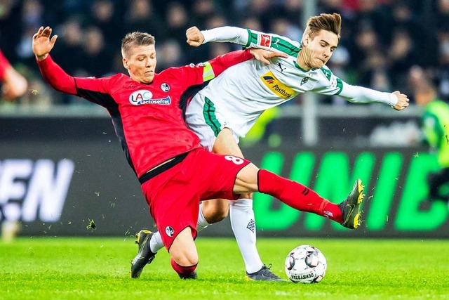 Freiburgs Mike Frantz (l) und Gladbachs Florian Neuhaus kmpfen um den Ball.  | Foto: dpa