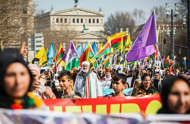 Mit zahlreichen Fahnen ziehen Teilnehm...urdischen Newroz-Fest durch die Stadt.  | Foto: dpa