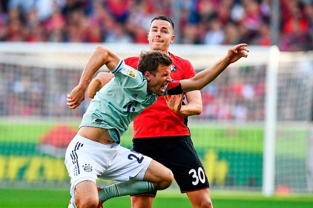 SC-Auenverteidiger Christian Gnter gegen Bayern-Kapitn Thomas Mller.  | Foto: AFP
