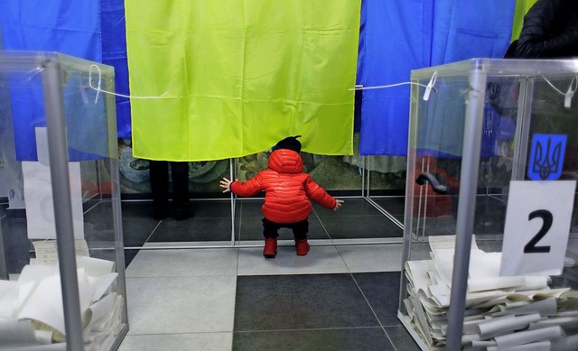 Fr wen wohl stimmen die Eltern? Ein K...tag vor einer ukrainischen Wahlkabine.  | Foto: dpa