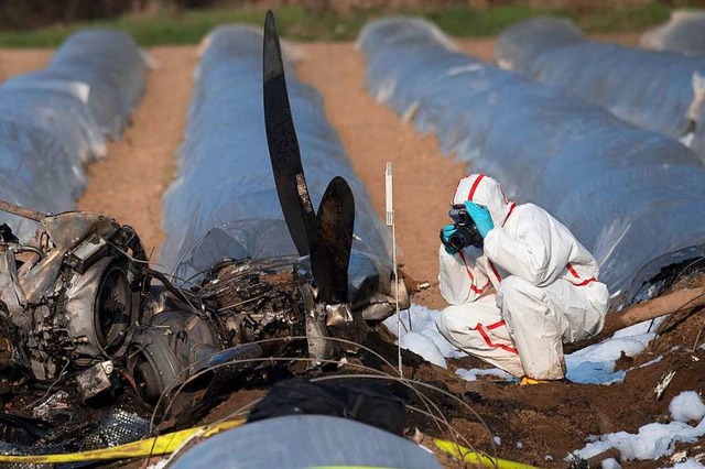 Beamte der Kriminalpolizei und Luftfah...in der Nhe des Flugplatzes Egelsbach.  | Foto: dpa