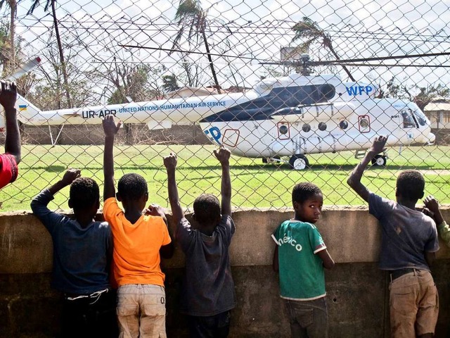 Kinder beobachten einen Hubschrauber der Vereinten Nationen.  | Foto: Johannes Dieterich