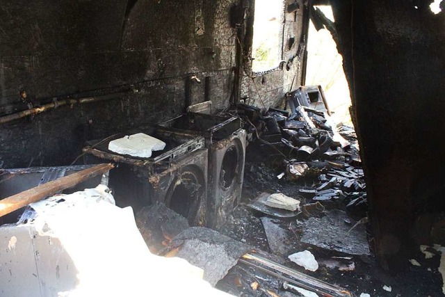 Nach dem Brand unbrauchbar: Waschmasch... der Htte. Hinten der verkohlte Ofen.  | Foto: Joshua Kocher