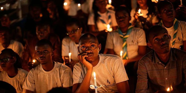 Menschen halten Kerzen, als sie am Son... Amahoro-Stadion in Kigali teilnehmen.  | Foto: dpa