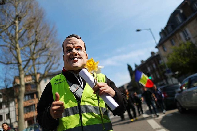 Ein Demonstrant der Gelbwesten trgt eine Macron-Maske.   | Foto: AFP