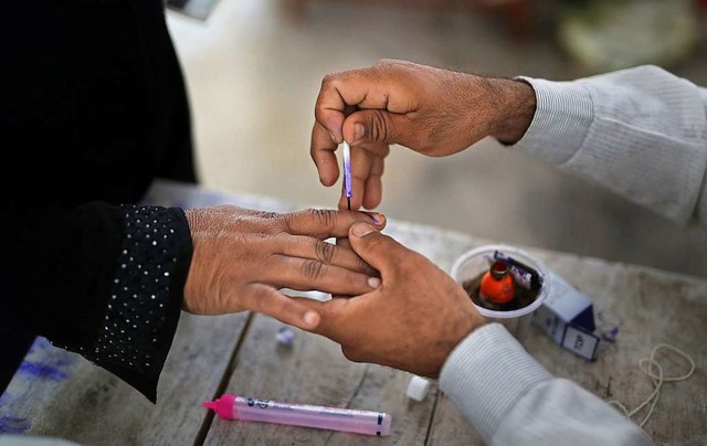 Ein Wahlhelfer frbt in einem Wahlloka... sieben Phasen bis zum 19. Mai statt.   | Foto: dpa