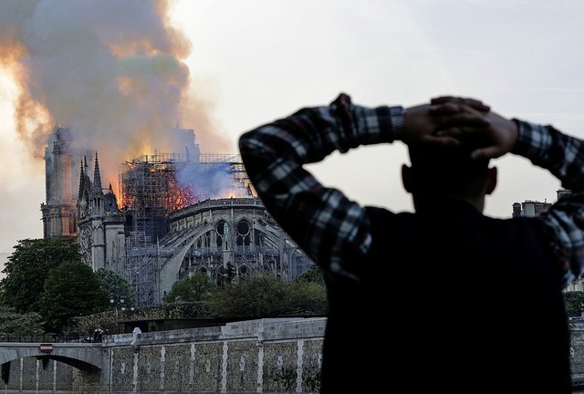 Ein Mann beobachtet mit Entsetzen, wie...eltberhmten Kathedrale niederbrennt.   | Foto: AFP