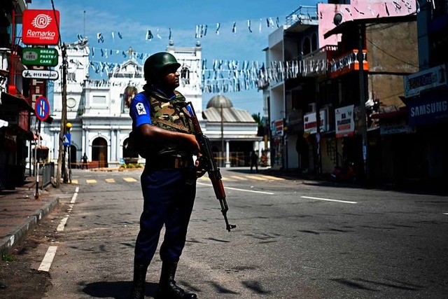Ein bewaffneter Soldat steht vor einer...en, die vom Terror heimgesucht wurden.  | Foto: AFP