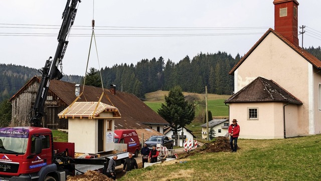 Das Toilettenhuschen schwebt per Kran...orbereitete Fundament bei der Kirche.   | Foto: Seifried