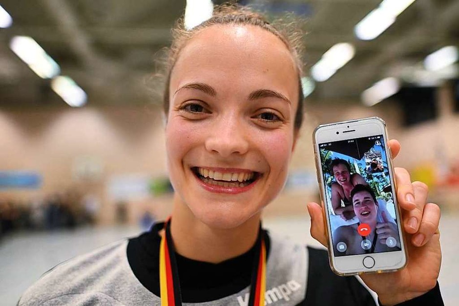 HSG-Spielerin Alica Burgert zeigt, dass Freunde und Familie auch über das Handy mitfeiern. (Foto: Patrick Seeger) HSG-Spielerin Alica Burgert zeigt, dass Freunde und Familie auch über das Handy mitfeiern. (Foto: Patrick Seeger)