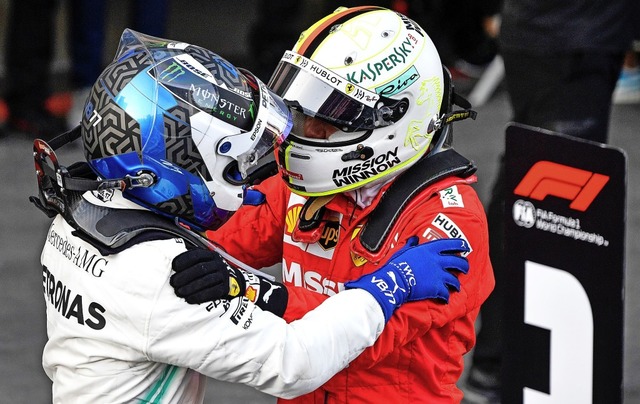 Gratulation mit Helm: Sebastian Vettel (rechts) beglckwnscht Valtteri Bottas.   | Foto: AFP