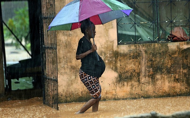 Eine Schwangere kmpft sich durch eine...in der  mosambikanischen Stadt Pemba.   | Foto: dpa