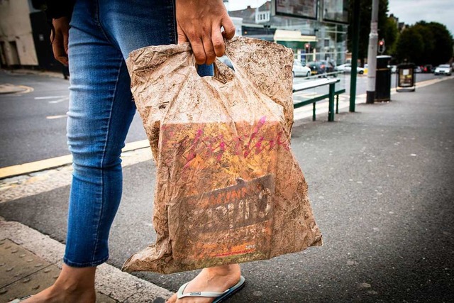 Eine Frau trgt eine Plastiktte, die ... lang Umwelteinflssen ausgesetzt war.  | Foto: dpa