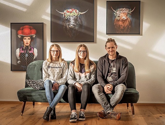 Laura, Fiona und Fotograf Sebastian Wehrle vor einer Wand mit Schwarzwaldkunst   | Foto: Sandra Wehrle