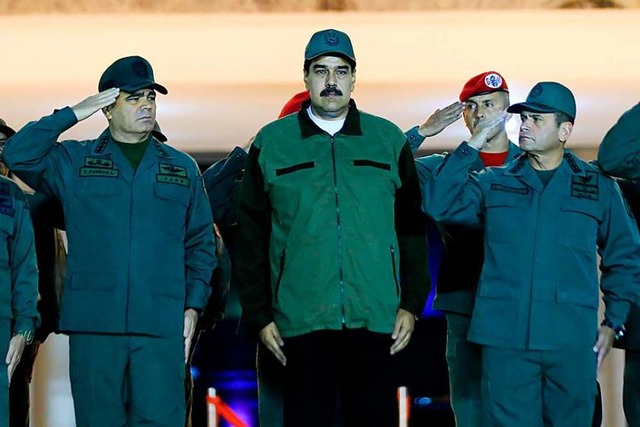 Die Offiziere stehen an seiner Seite: ...f einem Militrsttzpunkt in Caracas.   | Foto: AFP