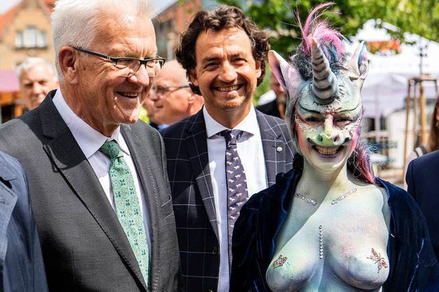 Winfried Kretschmann steht neben Cynthia Schneider im Einhornkostm.  | Foto: dpa