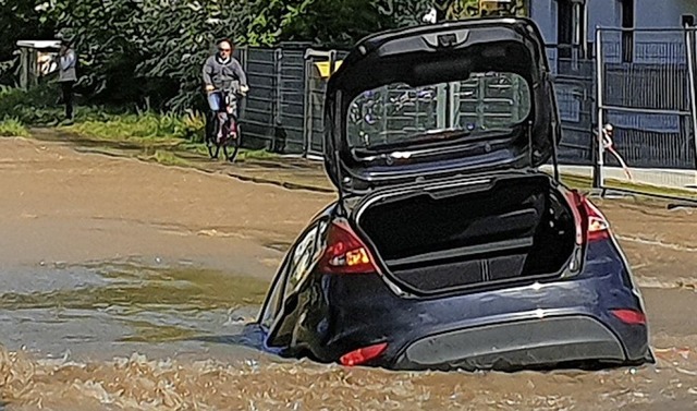 Das Auto versinkt auf einer normalerweise viel befahrenen Strae.  | Foto: dpa