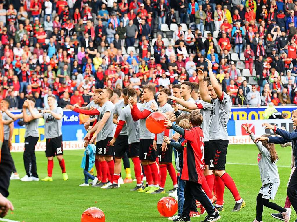 Vor dem Fest hinter der Nordtribne feiern die Spieler bereits im Stadion mit den Fans.