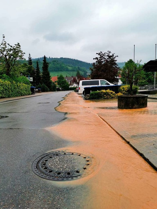 Die Wassermassen bahnen sich in Merzha...lang des Friedhofwegs vor dem Rathaus.  | Foto: Manuela Müller
