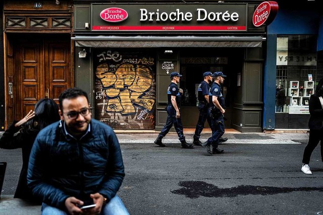 Polizisten laufen einen Tag nach der E...iale von Brioche Dore in Lyon vorbei.  | Foto: JEFF PACHOUD (AFP)