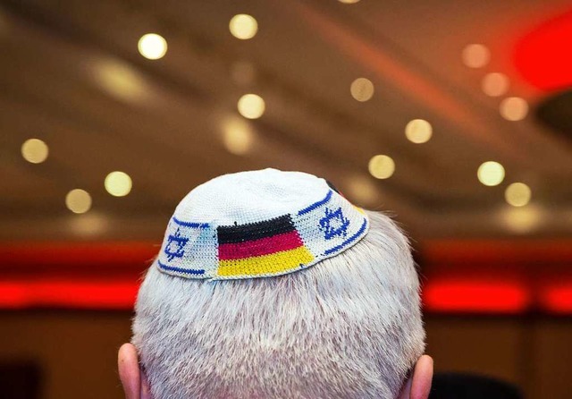 Ein Mann trgt eine Kippa mit eingearbeiteten israelischen und deutschen Fahnen.  | Foto: Frank Rumpenhorst (dpa)