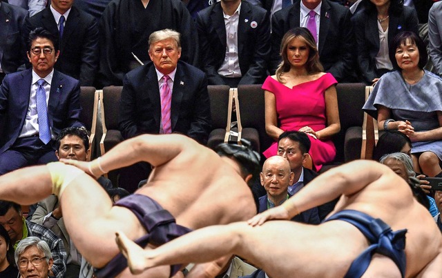 Japans Premier Shinzo Abe und seine Fr...inem Kampf von Sumo-Ringern in Tokio.   | Foto: BRENDAN SMIALOWSKI (AFP)
