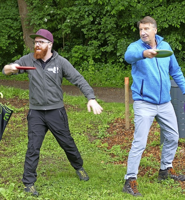 Rolf Rubsamen (rechts) lsst sich von ...g die Feinheiten von Discgolf zeigen.   | Foto: Victor Adolf