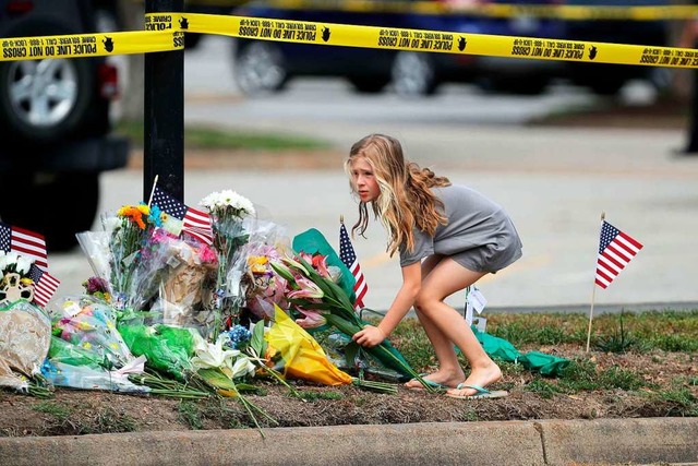 Ein Mdchen legt Blumen auf eine Rasen...de, in dem der Amoklufer gewtet hat.  | Foto: CHIP SOMODEVILLA (AFP)