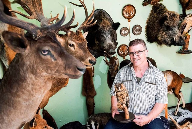 Tierprparator Michael Sens sitzt zwischen prparierten Wildtieren.   | Foto: Daniel Bockwoldt (dpa)