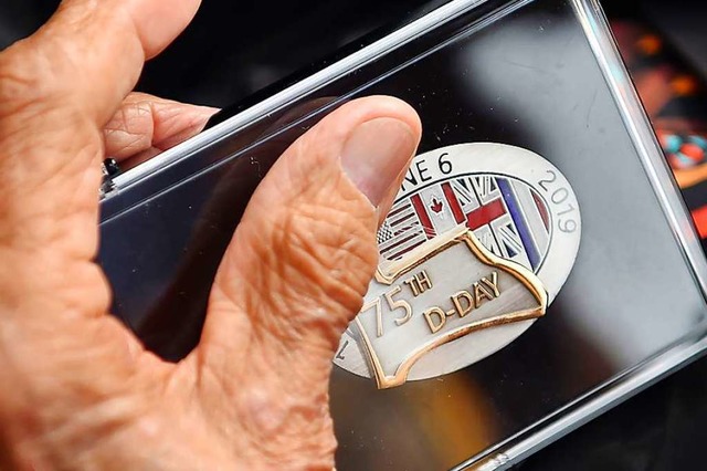 Ein Veteran hlt in seinen Hnden eine D-Day-Medaille  | Foto: LOIC VENANCE (AFP)