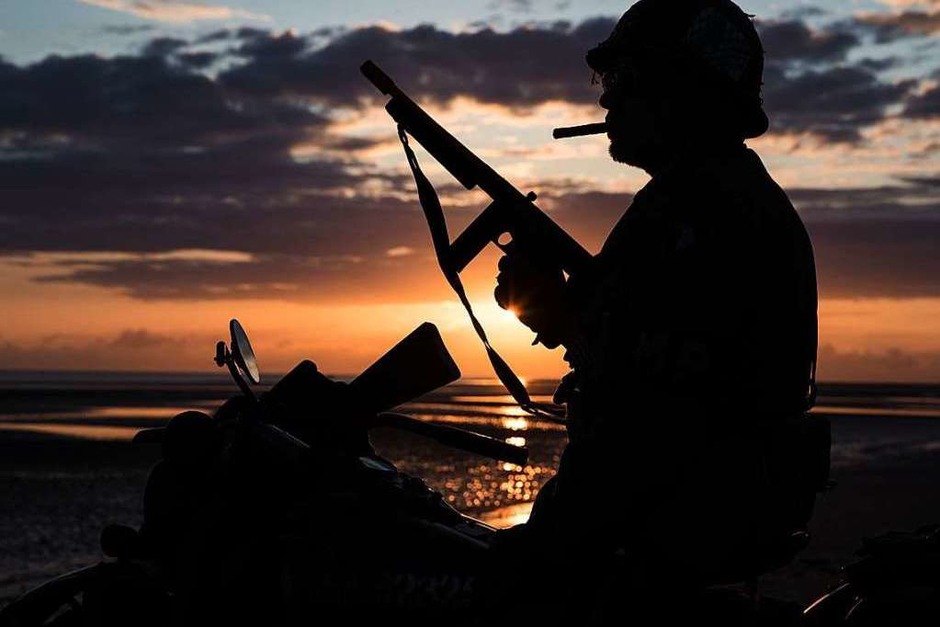 Silhouette eines Mannes in Uniform und auf historischem Motorrad am Strand von Arsnelles. (Foto: JOEL SAGET (AFP)) Silhouette eines Mannes in Uniform und auf historischem Motorrad am Strand von Arsnelles. (Foto: JOEL SAGET (AFP))