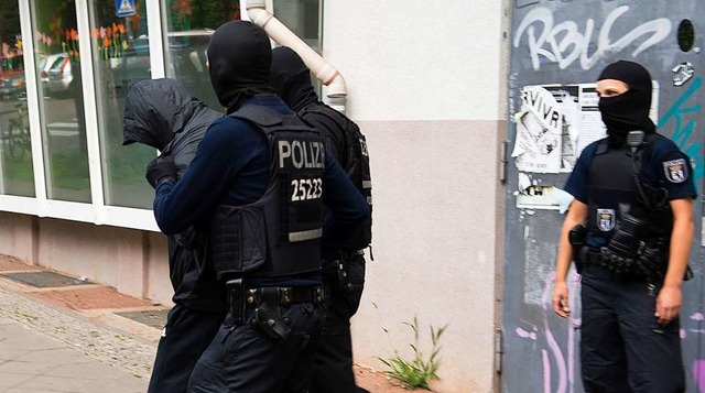 Clan-Kriminalitt: Polizisten fhren in Berlin einen Tatverdchtigen ab.  | Foto: Paul Zinken (dpa)