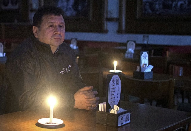 Ein Argentinier sitzt bei Kerzenschein in einer Bar.   | Foto: Mario De Fina (dpa)