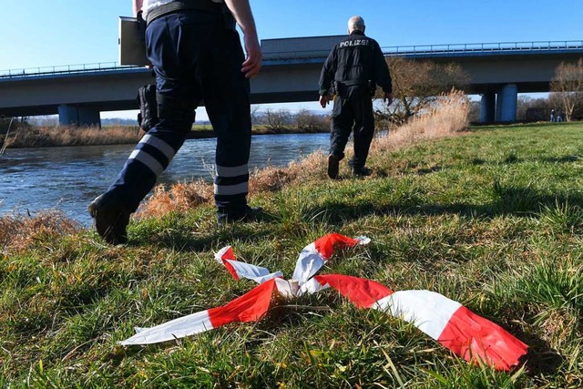 Polizeikrfte gehen am Ufer der Fulda ... in dem Fluss die Leiche eines Kindes.  | Foto: Uwe Zucchi (dpa)