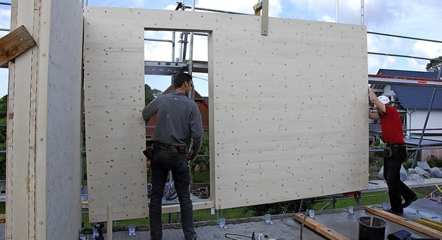 Zwei Zimmerleute bringen die Auenwand...n die Holzteile mit Planen geschtzt.   | Foto: Dorothea Scherle